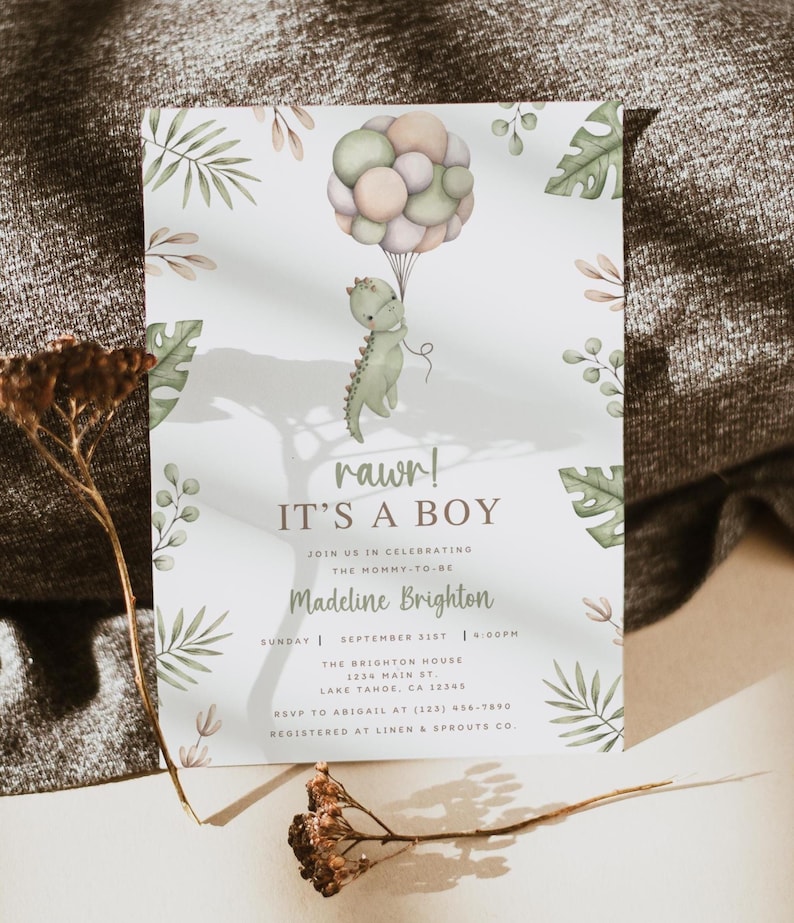 Op de afbeelding: Een witte uitnodigingskaart voor een babyshower met een aquarelillustratie van een groene dinosaurus die een tros pastelkleurige ballonnen vasthoudt. De tekst luidt rawr! IT'S A BOY, JOIN US IN CELEBRATING THE MOMMY-TO-BE, Madeline Brighton en evenementdetails.
