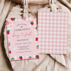 Berry first birthday invitation shows the front and bottom of the invite. The back of the invite has pink and whitegingham print. Photo shows the front and back of the invite laying flat.