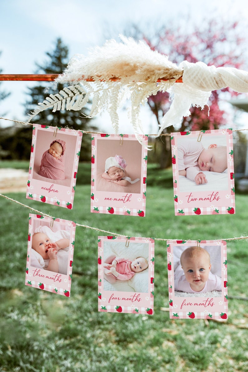 Photo shows 5x7” Berry 1st birthday photo cards hanging on clotheslines and paper clips outside.