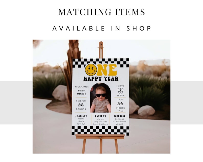 May include: A yellow and black birthday sign featuring a smiling face and the text "One Happy Year". The sign also includes details about the child's age, weight, height, and favourite foods.