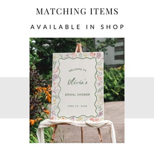 May include: A welcome sign for a bridal shower with a green, white and beige background. The sign has a floral border with a variety of colourful flowers and fruits. The text on the sign reads "Welcome to Olivia's Bridal Shower June 29, 2023".