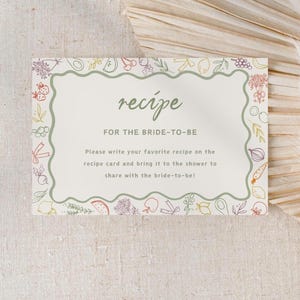 May include: A white card with a green border and a green wavy line around the text. The card has a hand-drawn illustration of vegetables and fruits around the border. The text on the card reads "recipe" in a green font and "FOR THE BRIDE-TO-BE" in a brown font. The text below reads "Please write your favourite recipe on the recipe card and bring it to the shower to share with the bride-to-be!"