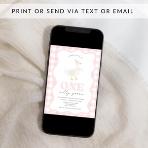 May include: A smartphone displays a pink and white invitation with the text "ONE silly goose" and a cartoon goose wearing a party hat. The invitation is framed with a pink gingham pattern. The phone is black and the background is white.