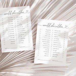 May include: Two printable "Would She Rather" game cards with a heart design. The cards feature a list of 16 questions with two choices each. The questions are about lifestyle preferences, such as sleeping in late or waking up early, reading a book or watching a film, and shopping online or shopping in a store.
