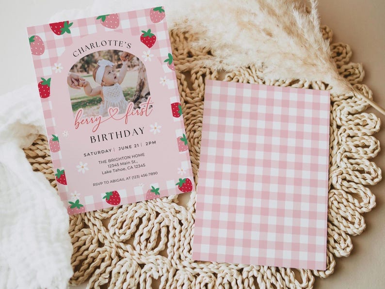 May include: Pink and white gingham patterned invitation with a photo of a baby girl in a white dress. The invitation says "Charlotte's Berry First Birthday" with the date and time of the party.