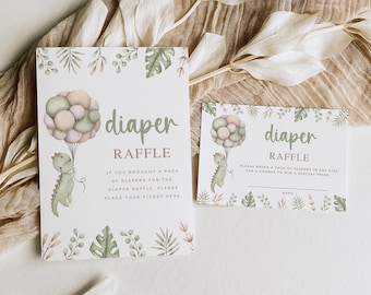 Op de afbeelding: Een verticaal luierloterijbord en een horizontale lotenkaart met een aquarelillustratie van een groene dinosaurus die pastelkleurige ballonnen vasthoudt, omringd door botanische bladeren en de tekst Diaper Raffle.