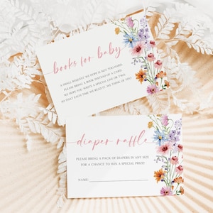Puede incluir: Dos tarjetas de baby shower con diseños florales. Una tarjeta dice "libros para bebé" y la otra "rifa de pañales". Ambas tarjetas tienen un borde floral con flores rosas, moradas, naranjas y azules. Las tarjetas están sobre una bandeja decorativa.