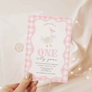 May include: A pink and white invitation card with a gingham border and a cartoon goose wearing a party hat. The text reads "ONE silly goose" and includes event details. A white envelope with a wax seal is also visible.