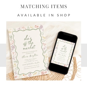 May include: A green and white illustrated card with the text "she's off the market" and a floral border. The card is a bridal shower invitation for Olivia Brighton. The card is displayed on a phone screen and a wicker surface.
