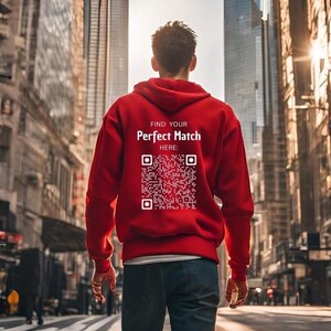 Könnte beinhalten: Ein roter Hoodie mit einem weißen QR-Code und dem Text "Find Your Perfect Match Here:" auf der Rückseite.