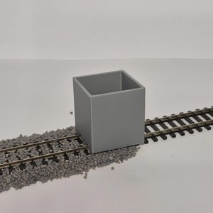 Puede incluir: Una taza de cerámica blanca con un asa negra y el texto "But First, Coffee" en negro, con una fuente de estilo manuscrito. La taza está sobre una superficie blanca.