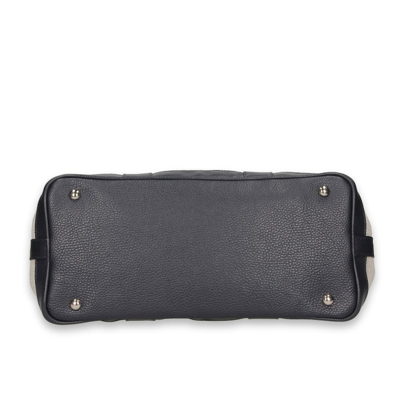 Pu&ograve; includere: Una borsa grigio scuro con esterno in pelle strutturata. Il fondo della borsa presenta quattro piedini in metallo argentato. I lati della borsa hanno un design a righe nere e beige. La borsa &egrave; uno stile a manico superiore.