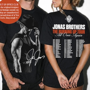 May include: A black t-shirt featuring a graphic of a person in a hat on the front with a signature, and the back displays the text JONAS BROTHERS THE BURNING UP TOUR All Over Again with a list of tour dates and locations in white and orange.