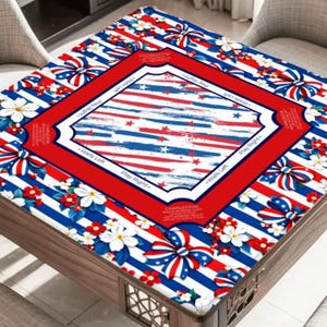 May include: A square table cover with a patriotic design. The cover features red, white, and blue stripes, stars, and floral accents. The center has a red border with text. The table is made of wood.