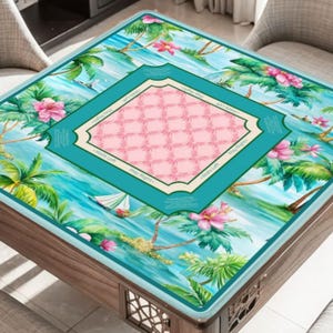 May include: A square game table cover featuring a tropical design with palm trees, pink flowers, and a sailboat. The center has a pink grid pattern within a teal frame. The edges are teal with text.