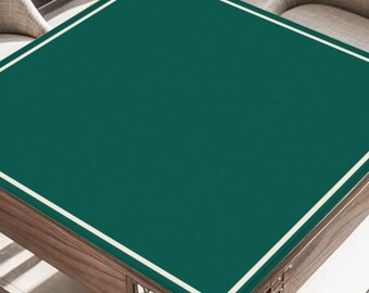 May include: A square, wooden table with a dark green surface and a white border. The table has a decorative wooden base with intricate cut-out designs. The table is surrounded by two chairs.