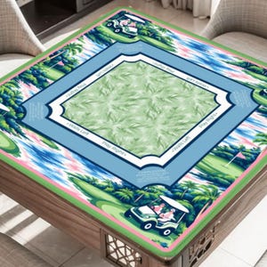 May include: A square table cover featuring a golf course design. The cover has a green border with palm trees and golf carts. The center has a blue and white frame with text that says "Play Right" and "Walls Left". The center has a green leaf pattern.