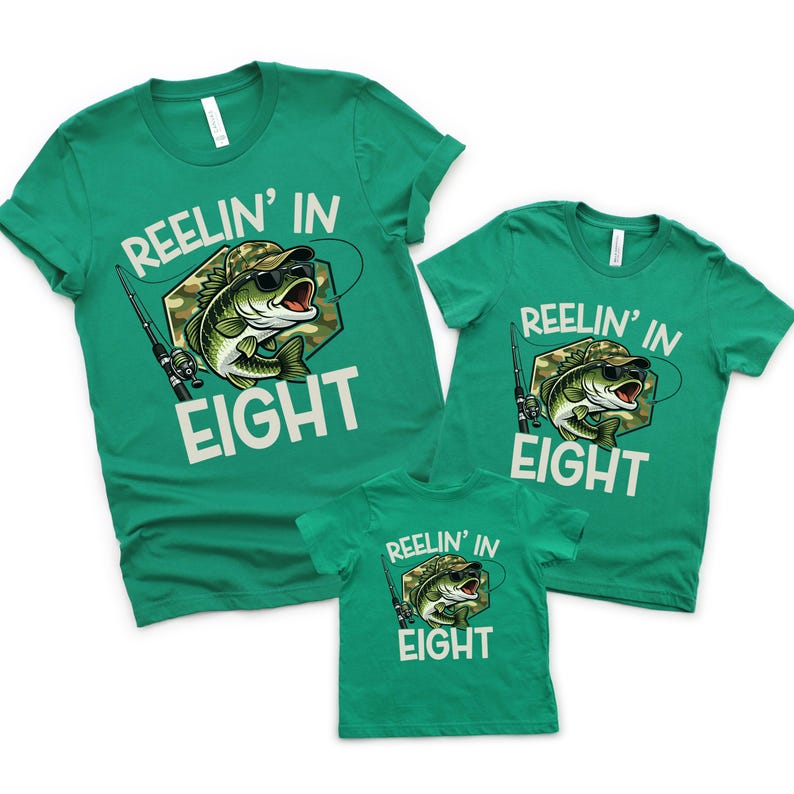 Puede incluir: Tres camisetas verdes con el texto "REELIN' IN EIGHT" y un gr&aacute;fico de un pez con gafas de sol y un sombrero de camuflaje. Las camisetas son de diferentes tallas, lo que sugiere un conjunto familiar.
