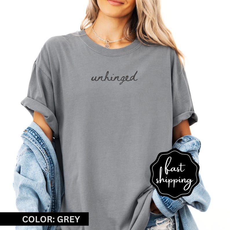 May include: A grey t-shirt with the text "unhinged" printed on the front in black.