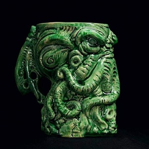 May include: Green ceramic mug shaped like a tentacled monster with a skull at the base.