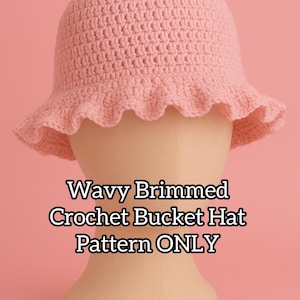 May include: A light pink, crocheted bucket hat with a wavy brim, displayed on a mannequin head against a pink backdrop. The text "Wavy Brimmed Crochet Bucket Hat Pattern ONLY" is visible.