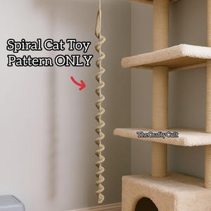 Może przedstawiać: Beżowa spiralna zabawka dla kota zawieszona na drapaku. Na zdjęciu widnieje napis "Spiral Cat Toy Pattern ONLY". Drapak ma wiele poziomów i słupków do drapania.