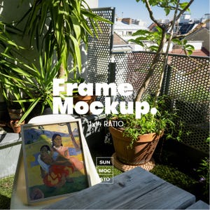 Puede incluir: Una obra de arte enmarcada con una pintura de dos mujeres en un entorno tropical, apoyada contra una silla en un balcón. El marco es de color claro. La imagen está etiquetada como "Frame Mockup" con una proporción de 28x36 cm. También se ven plantas en macetas y una mesa de madera.