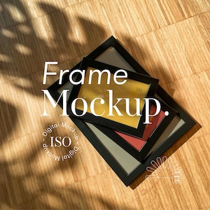 May include: A stack of black picture frames with various colored mats, including gold, red, and gray, are arranged on a wooden surface. The text "Frame Mockup" is overlaid on the image, along with additional text and a logo.