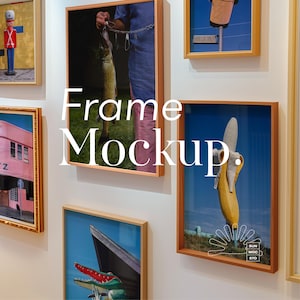 May include: A white wall with a variety of framed pictures. The pictures include a man holding a fish, a banana, a building, and a toy soldier. The text "Frame Mockup." is written in white letters on the wall.