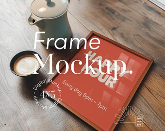 May include: A wooden picture frame mockup with a red background and the text "Happy Hour" in white letters. The frame is sitting on a wooden table with a cup of coffee and a white teapot.