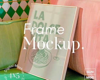 May include: A gold frame mockup with a white background and a drawing of a plate of spaghetti and a glass of wine. The text "La Dolce Vita" is visible in the frame. The frame is sitting on a green and pink couch.