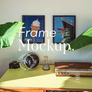 May include: A digital mockup of a 3x4 frame with two framed pictures, one with an ice cream cone and the other with a cartoon alligator. The frames are on a yellow table with a vintage phone, a camera, and a record player.