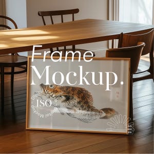 May include: A wooden frame mockup with a fish illustration inside. The frame is sitting on a wooden floor in a room with a wooden table and chairs.