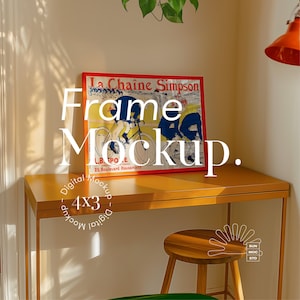 May include: A digital mockup of a 4x3 frame with a vintage poster of cyclists. The frame is on a wooden desk with a stool and a plant in the background.