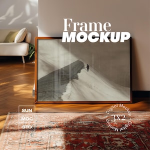 Pode incluir: Uma moldura de madeira marrom com uma imagem de uma cena de montanha nevada. A moldura está sobre um tapete vermelho e laranja com um padrão. O texto "Frame Mockup" está escrito em letras brancas sobre um fundo preto acima da moldura. O texto "Digital Mockup 3x2 Digital Mockup" está escrito em um círculo abaixo da moldura.