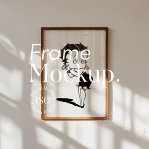 Puede incluir: Un marco de madera marrón con un paspartú blanco y una ilustración en blanco y negro de un personaje de dibujos animados. El texto "Frame Mockup" está escrito en letras blancas en la imagen. El texto "Digital Mockup - ISO - Digital Mockup" está escrito en un círculo en la esquina inferior izquierda de la imagen.