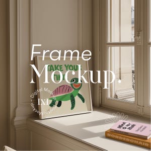 May include: White frame mockup with a green and pink turtle illustration inside. The frame is sitting on a white surface with a book titled "Mind Over Meh" and "BORDERCHAIR" on top of it.