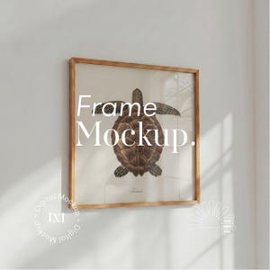 Könnte beinhalten: Ein quadratischer Holzrahmen mit einem Druck einer braunen Meeresschildkröten-Illustration auf hellem Hintergrund. Der Text "Frame Mockup." ist in Weiß überlagert. Zusätzliche kreisförmige Textlogos "Digital Mockup IXI" und "SUN MOC STO" sind zu sehen.