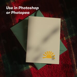 May include: A cream-coloured greeting card with a yellow sun logo and the text "SUN MOC STO" is placed on a green envelope. The card and envelope rest on a red and green plaid blanket. The text "Use in Photoshop or Photopea" is at the top.
