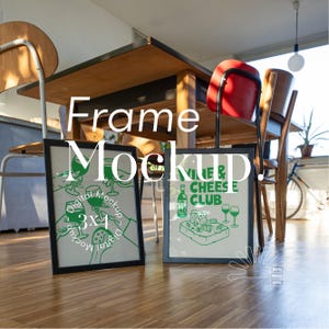 May include: Two black picture frames with white mats on a wooden floor. The frame on the left has a green illustration of hands holding wine glasses with the text "Digital Mockup 3x4 Digital Mockup". The frame on the right has a green illustration of a bottle of wine, cheese, and wine glasses with the text "Wine & Cheese Club".