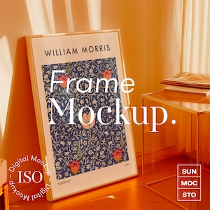 Könnte beinhalten: Ein weißer Rahmen mit goldener Umrandung, der einen floralen Druck in Rot- und Blautönen zeigt. Der Rahmen lehnt an einem goldfarbenen Tisch mit Glasplatte. Der Text "WILLIAM MORRIS" und "Frame Mockup." ist auf dem Rahmen sichtbar.