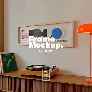 May include: A framed geometric art print with pink, black, and blue shapes hangs above a wooden console. A record player with a black vinyl record sits on the console. The text "Frame Mockup" and "3 x 1 RATIO" is visible.