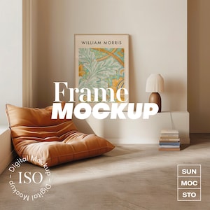 Op de afbeelding: Een digitale mockup van een ingelijst drukwerk met een bloemenmotief. De lijst is wit en de print is een lichtblauw, groen en geel bloemenpatroon. De tekst "WILLIAM MORRIS" is bovenaan de lijst gedrukt. De lijst hangt aan een witte muur. Een bruine leren fauteuil staat op de voorgrond. De tekst "Frame MOCKUP" is in wit op een bruine achtergrond gedrukt. De tekst "Digital Mockup - ISO - Digital Mockup" is in een cirkel in de linkerbenedenhoek van de afbeelding gedrukt. De tekst "SUN, MOC, STO" is in een wit vak in de rechterbenedenhoek van de afbeelding gedruckt.