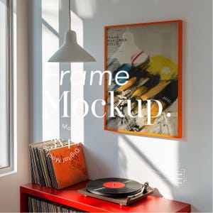 Puede incluir: Un estante rojo con un tocadiscos y una pila de discos de vinilo. Un póster enmarcado con el texto "PRAHA WARSZAWA BERLIN" cuelga en la pared detrás del estante. El póster está en un marco naranja.