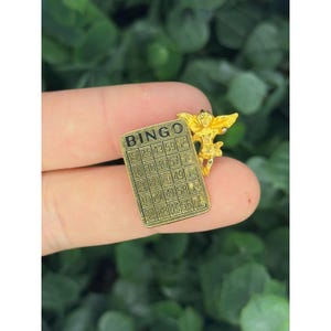 Broche de solapa con forma de tarjeta de bingo vintage, con forma de ángel y amuleto de la buena suerte, tono dorado