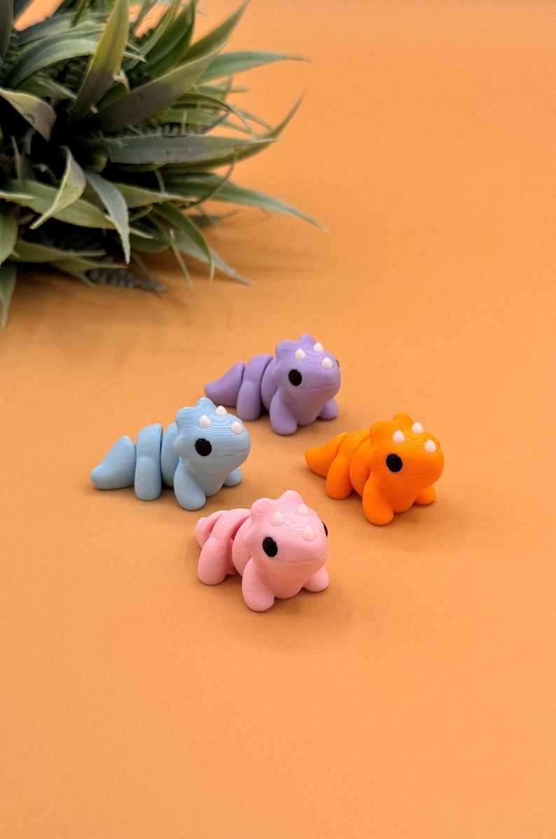 Triceratops fidget toys come in blue, purple, orange, and pink.