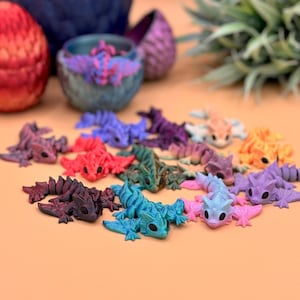 3D printed wyvern dragon toys come in a variety of colors including metallic red, teal, purple, gold, green, and more.