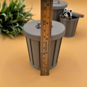 Large trash can storage container and racoon fidget toy.