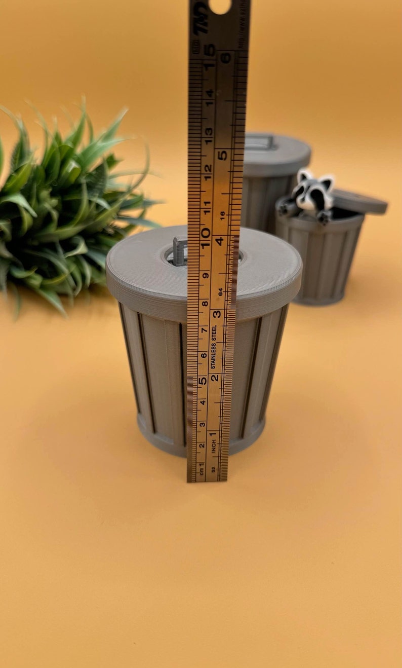Large trash can storage container and racoon fidget toy.
