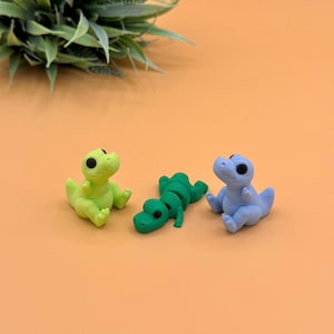 Sitting and laying t-rex 3D printed toys.